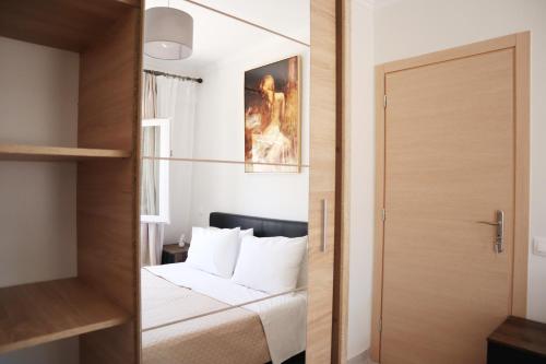 una piccola camera con letto e porta in legno di Aegean Front Gem Stylish Home a Samos