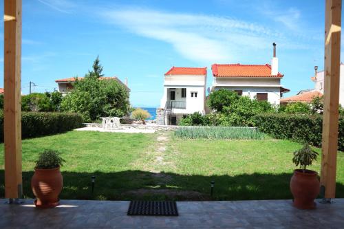 a house with a yard with two potted plants at Aelia Summer House in Samos