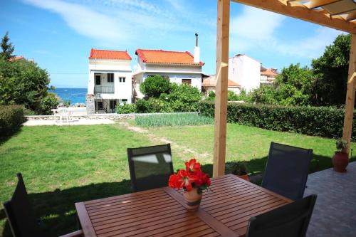 a wooden table with a vase of flowers on a patio at Aelia Summer House in Samos