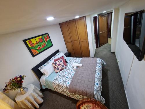 a small room with a bed and a television at Habitaciones en Edificio Ginebra Manizales in La Linda