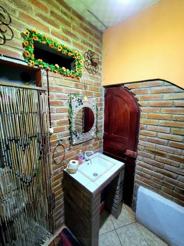 a bathroom with a sink and a brick wall at Hostal Leyendas in León