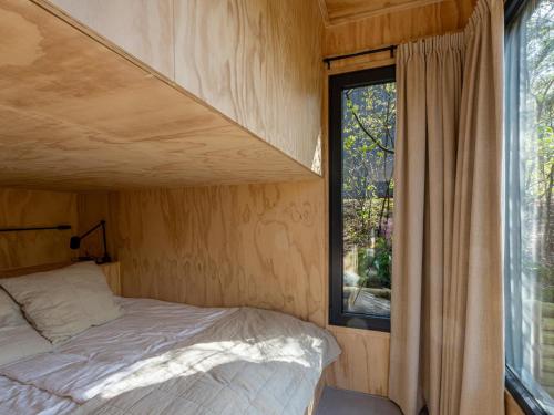 een kleine slaapkamer met een bed en een raam bij Mos in Nunspeet