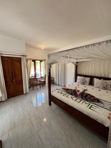 um quarto com uma cama de dossel grande em Salabose Cottages em Gili Air
