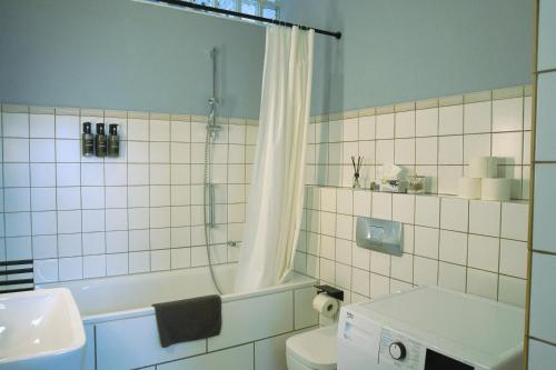 a bathroom with a tub and a toilet and a sink at No.1 by 21Apartments in Krefeld