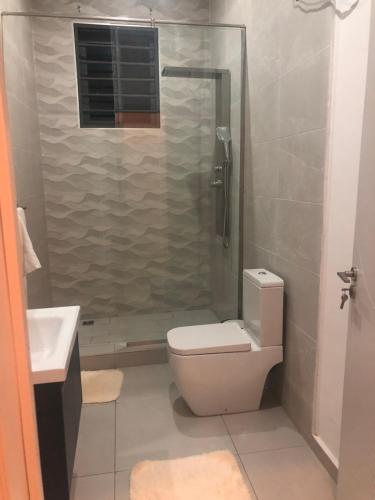 a bathroom with a shower and a toilet and a sink at Suville in Accra