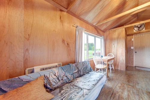a living room with a couch and a table at Dog-Friendly Cabin Near Pymatuning Lake! in Williamsfield