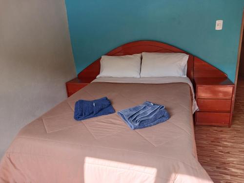 a bed with two blue towels on top of it at Lia B&B Lucmabamba in Sahuayacu