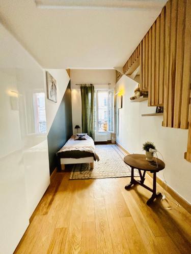 une chambre avec un lit et une table dans une pièce dans l'établissement Splendid atypical loft st germain, à Paris