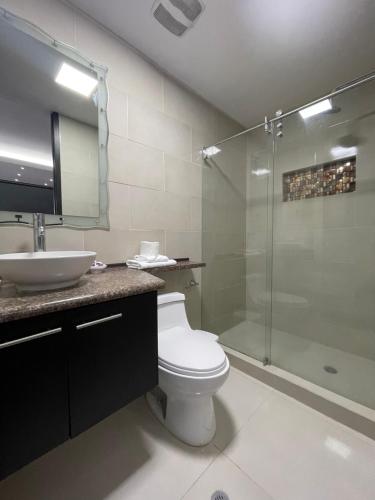 uma casa de banho com um WC, um chuveiro e um lavatório. em ItsaHome Apartments - Torre Aqua em Quito