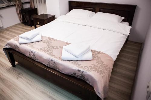 a bed with two white pillows on top of it at Pensiunea Almas in Piatra Neamţ