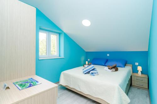 a blue bedroom with a bed and a window at Apartments with parking space Banici, Dubrovnik - 23176 in Slano