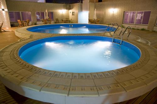 a hot tub in a circular pool with blue water at Global Hotel in Centenario