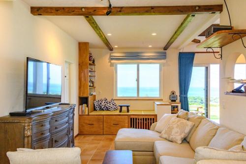 a living room with a couch and a tv at ZARATAN in Motobu