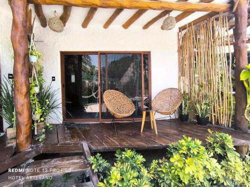 a porch with two chairs and a table at Arte Sano Hotel Only Adults - Near Beach in Holbox Island