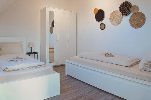 a white room with two beds and a mirror at No2 by 21 Apartments in Kaarst