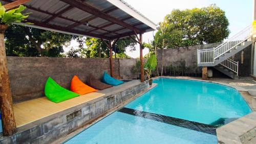 a bench with colorful pillows next to a swimming pool at Menjangan View in Banyuwedang