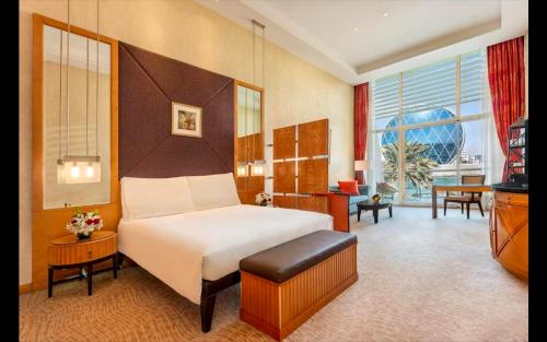 Al Raha Beach Hotel - Deluxe Gulf Room SGL - UAE في أبوظبي: فندق غرفه بسرير وصاله