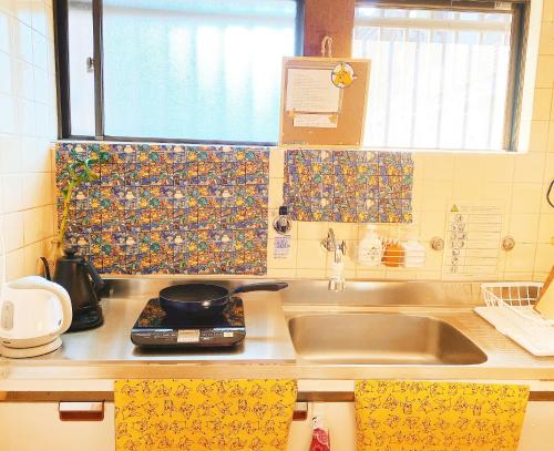 a kitchen counter with a sink and a window at Pokémon Sleep 宝可梦的家 in Osaka