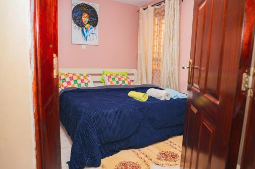 a bedroom with a bed with a blue comforter at Cosy 1-bedroom Hideout outside the city limits in Ruiru