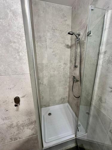 a shower with a glass door in a bathroom at Pod Papugami - Komfortowe pokoje z widokiem na rzekę in Łeba