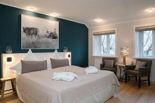 ein Schlafzimmer mit einem großen Bett, auf dem Handtücher liegen in der Unterkunft Ferienanlage Landliebe Appartement 5 in Alkersum