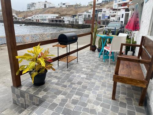 een patio met stoelen, een grill en een tafel bij BAHÍA SUR HOUSE - San Bartolo in San Bartolo
