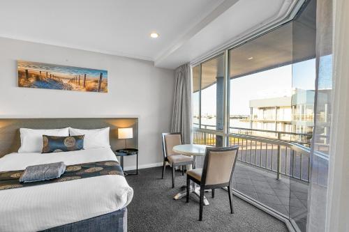 a hotel room with a bed and a balcony at Hilton Motel in Port Lincoln