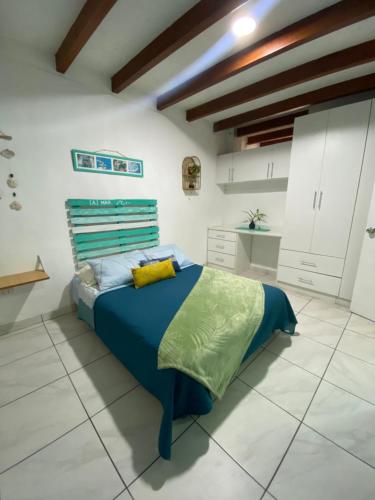 1 dormitorio con 1 cama azul en una habitación blanca en BAHÍA SUR HOUSE - San Bartolo, en San Bartolo