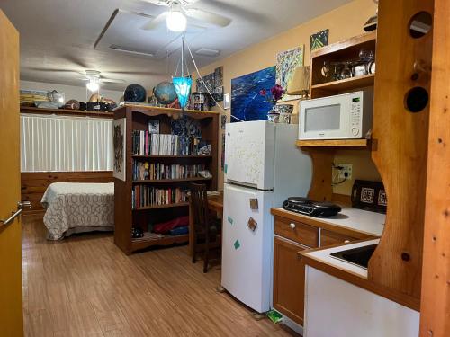 a kitchen with a white refrigerator and a book shelf at Miami Bungalow Oasis near Everglades & The Keys in Cutler Bay