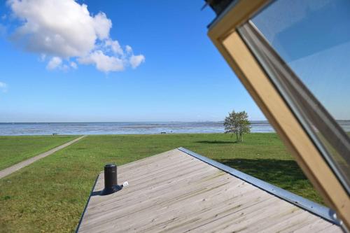 a view of the ocean from a house window at Tiny House Pioneer 1 - Green Tiny Spot Schillig in Wangerland