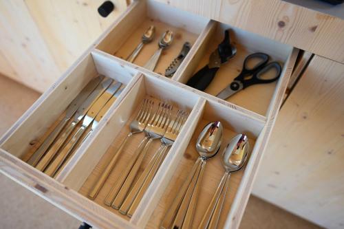 a drawer with utensils in a wooden box at Tiny House Pioneer 1 - Green Tiny Spot Schillig in Wangerland