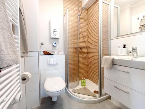 a bathroom with a shower and a toilet and a sink at Tief 10 „Meerblick Deck 9“ in Wangerland