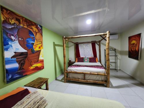 1 dormitorio con 1 cama y una pintura en la pared en Villa Rosa, en Punta Rucia