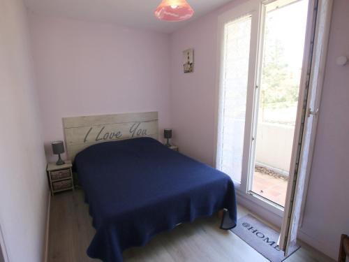 um quarto com uma cama azul e uma grande janela em Appartement Saint-Brevin-les-Pins, 3 pièces, 4 personnes - FR-1-364-43 em Saint-Brevin-les-Pins