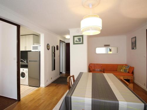 une cuisine et un salon avec une table et un canapé dans l'établissement Appartement T3 au Mont-Dore - Balcon, Parking, Proche Centre Ville, 6 Pers, Charges Incluses - FR-1-415-147, à Le Mont-Dore