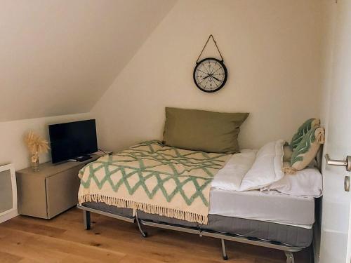 une chambre avec un lit et une horloge au mur dans l'établissement Studio Neuf Proche Plage avec Commodités et Parking - Fort-Mahon-Plage - FR-1-482-142, à Fort-Mahon-Plage