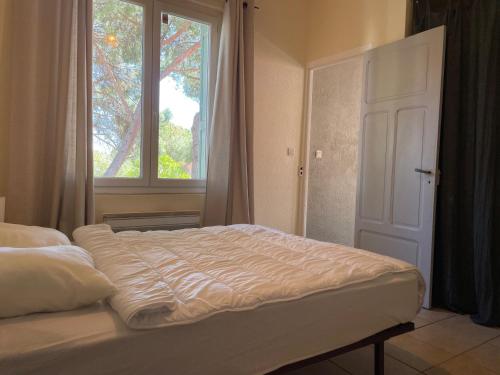 un lit dans une chambre avec une grande fenêtre dans l'établissement Argelès-sur-Mer : T2 rénové proche mer, clim, wifi, 4 couchages, balcon - FR-1-309-447, à Argelès-sur-Mer