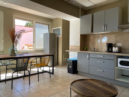 une cuisine avec une table et une salle à manger dans l'établissement Argelès-sur-Mer : T2 rénové proche mer, clim, wifi, 4 couchages, balcon - FR-1-309-447, à Argelès-sur-Mer