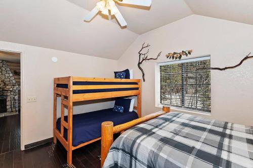 ビッグ・ベアー・レイクにあるSunrise Pines Cabin Near the Villageのベッドと天井扇風機のある寝室