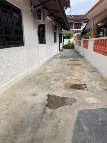 an empty courtyard of a white building with a lot of dirt at Homestay Cikgu Sayang in Melaka