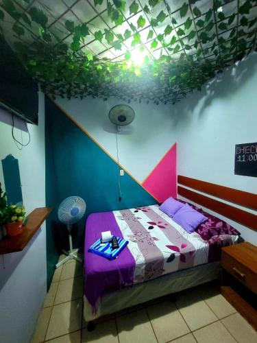a bedroom with a bed with a purple comforter at Hostal Leyendas in León