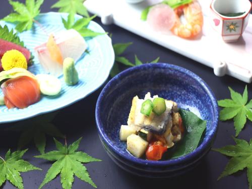 a blue bowl of food on a table with sushi at Hotel Miki in Gero