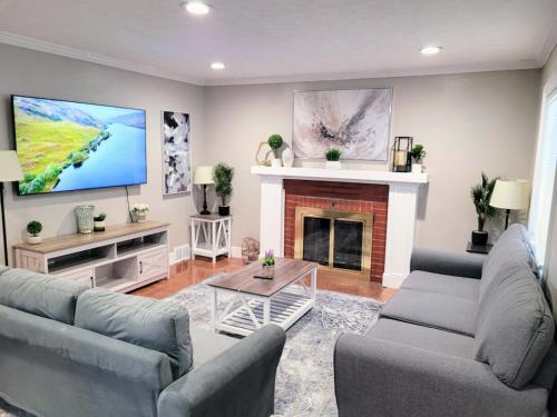 a living room with two couches and a fireplace at Sweet home, King bed, backyard and parking in Buffalo