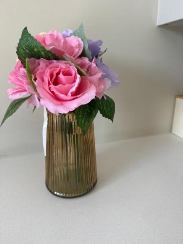 a vase filled with pink and purple flowers at Gallagher Midrand BnB in Midrand