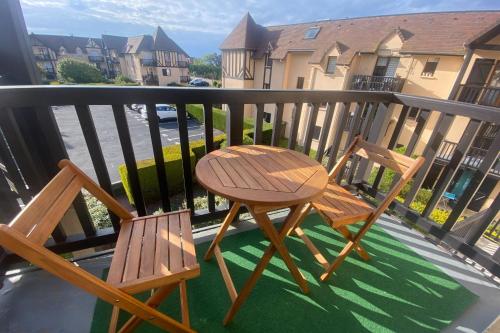 - deux chaises en bois et une table sur un balcon dans l'établissement Cozy cocoon a few steps from the sea, à Ouistreham