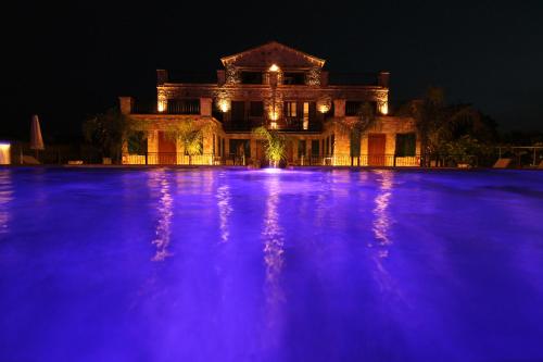 ein großes Haus mit lila Lichtern davor in der Unterkunft Limni Resort in Ksamil