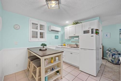 a kitchen with white cabinets and a white refrigerator at Cherry Grove efficiency just steps from the beach in Myrtle Beach