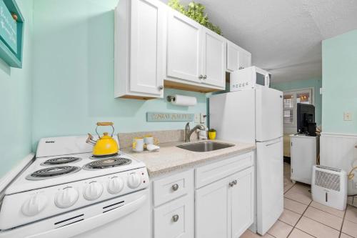 a kitchen with a stove and a white refrigerator at Cherry Grove efficiency just steps from the beach in Myrtle Beach