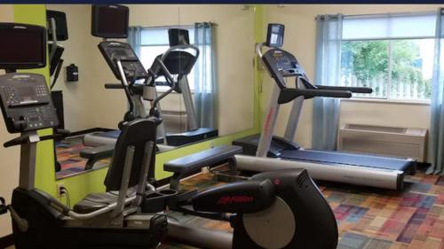 a gym with several exercise machines in a room at AmericInn by Wyndham Moline Airport/Quad Cities in Moline