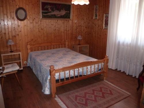 une chambre avec un lit dans une pièce en bois dans l'établissement Charmant 3 pièces avec balcon, proche centre et remontées mécaniques, Châtel - FR-1-676-35, à Châtel